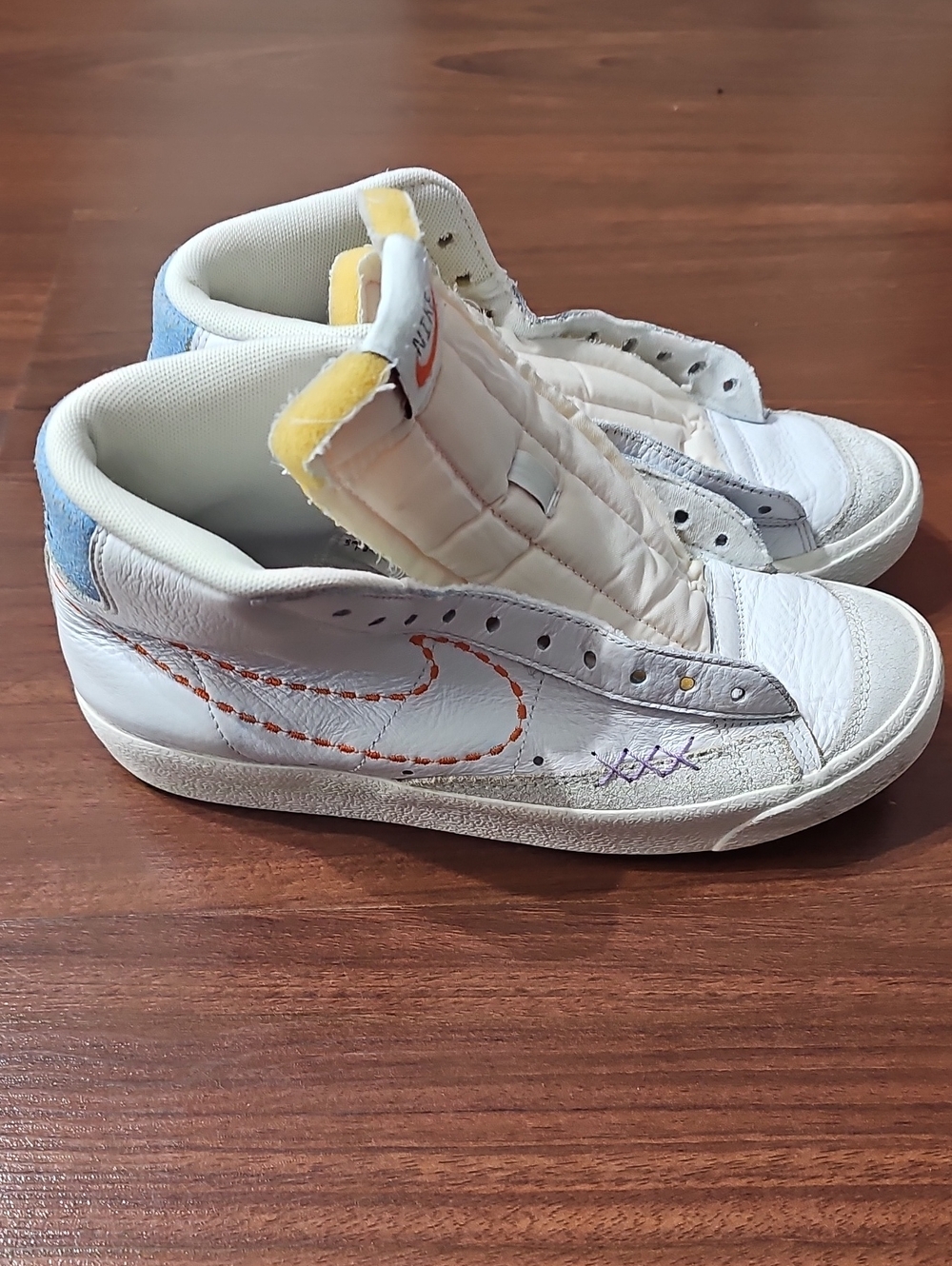 Nike White High-Top Sneakers with Orange Stitching and Blue Heel Accent
